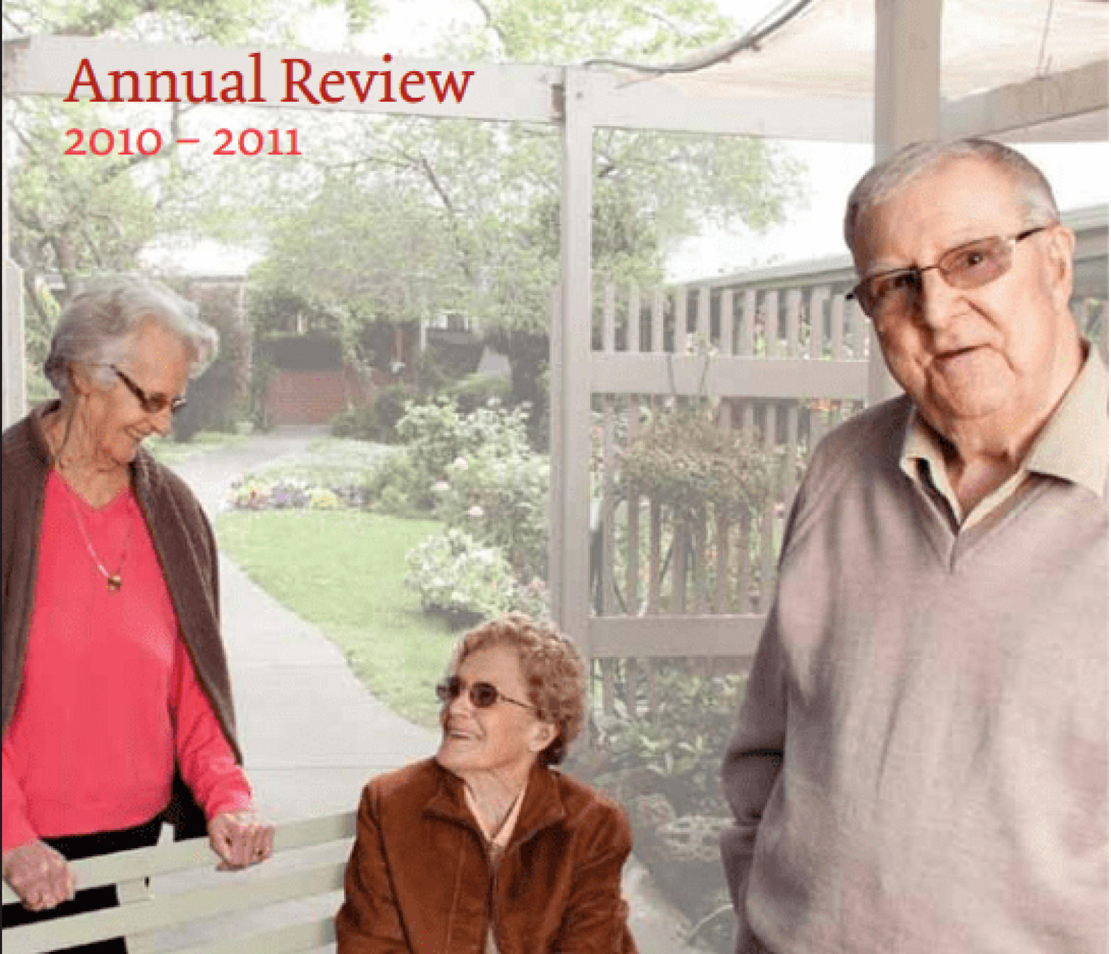 Cover of the Annual Review 2010–2011 featuring three older adults in a landscaped courtyard setting. One person stands beside a bench while another sits and looks up toward them, with a third person standing in the foreground. Gardens, pathways and outdoor seating create a welcoming community environment. Visible text reads: “Annual Review 2010–2011”.