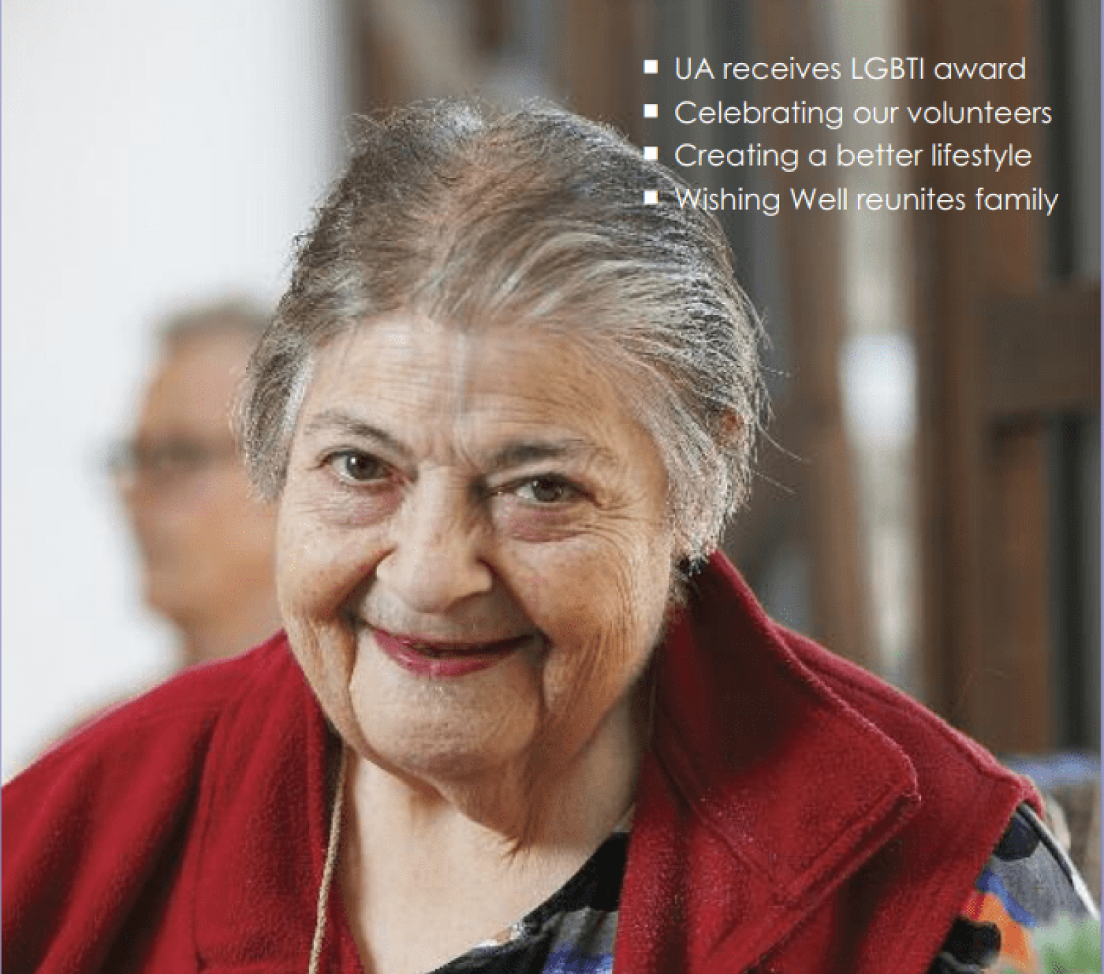 Close-up portrait of an older adult wearing a red vest, with a blurred indoor background. White text in the top-right corner highlights key stories: “UA receives LGBTI award”, “Celebrating our volunteers”, “Creating a better lifestyle”, and “Wishing Well reunites family”. The image appears to be a cover or promotional feature highlighting community achievements and stories.