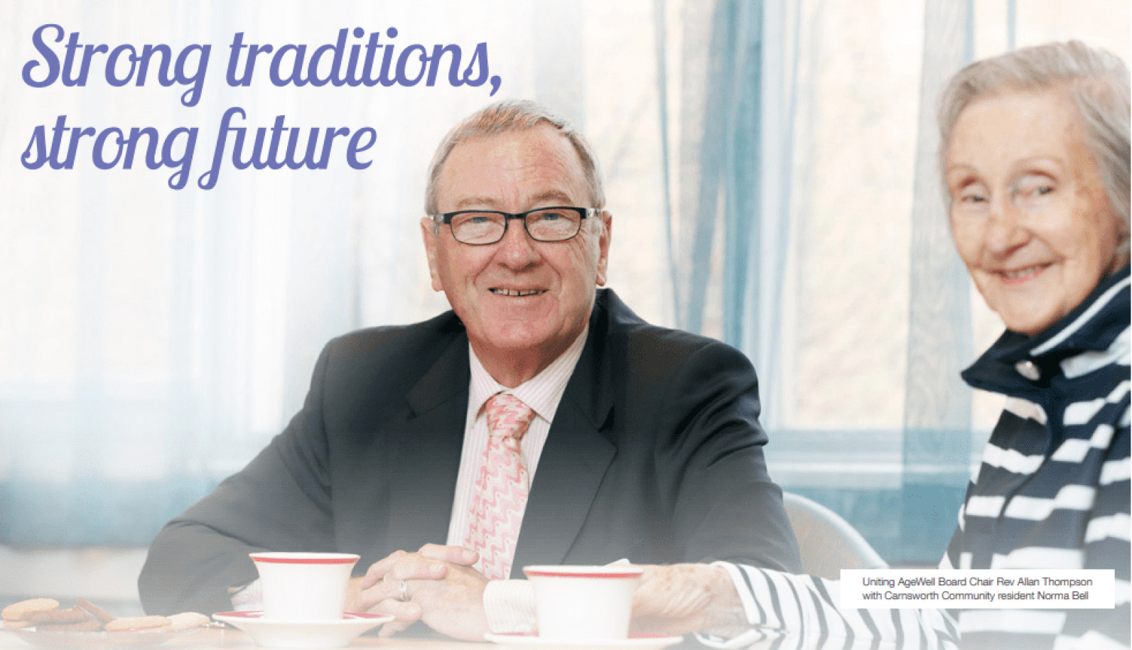 Cover image featuring two people seated at a table with cups of tea in a bright indoor setting. A person in a suit and glasses sits facing the camera, while another person is seated beside them. Large text reads: “Strong traditions, strong future”. A small caption identifies the image as featuring a Uniting AgeWell board chair and a community resident.