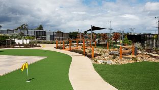 Rocky garden space with mini putting green, bridge and pergola pictured