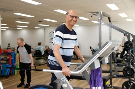 A Uniting AgeWell customer is using the gym equipment.