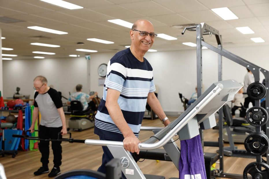 A Uniting AgeWell customer is using the gym equipment.