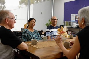 A group of customers are pictured sitting at the table and chatting with each other.