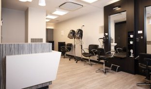 Hair salon with front desk and salon chairs pictured.