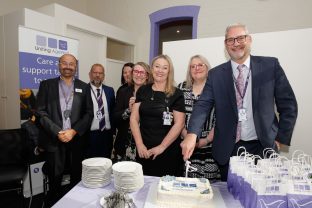 A few people are pictured cutting the celebration cake.