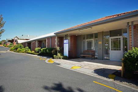 The community's front door featured under a beautiful sky, with a driving lane featured.