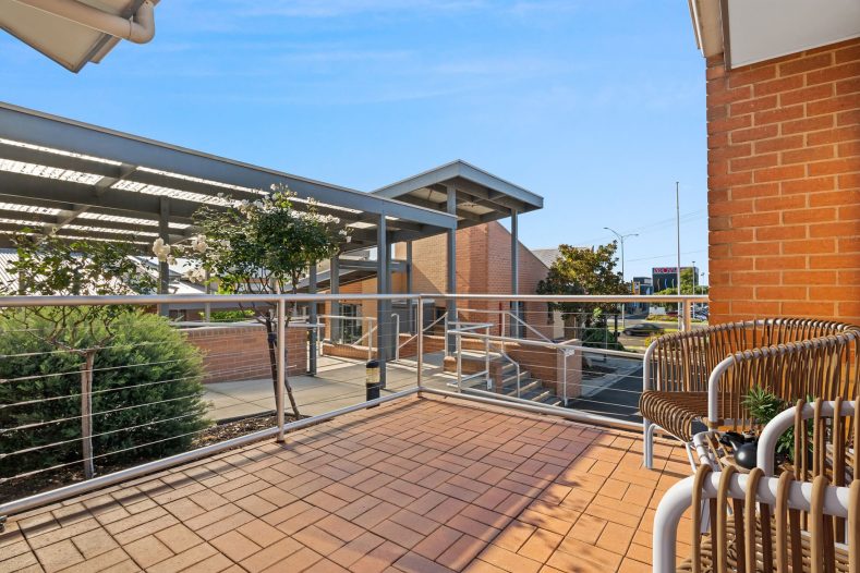 A balcony is photographed with chairs available.