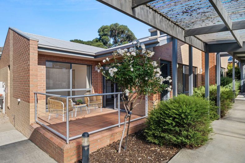 A house is captured from the side with walking pathways around