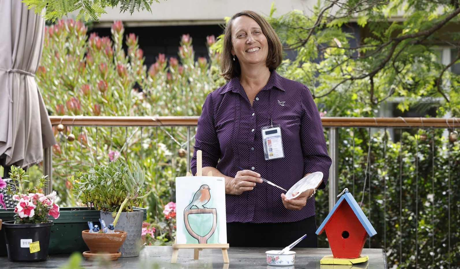 Lifestyle Coordinator at table setting up outdoor painting activity.
