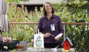 Lifestyle Coordinator at table setting up outdoor painting activity.