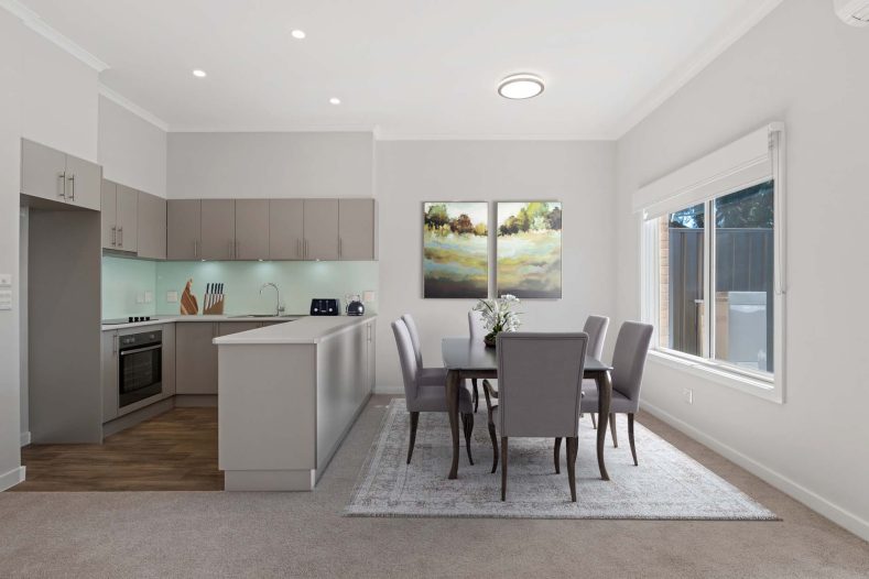 The dining room features a dining table near the open kitchen.