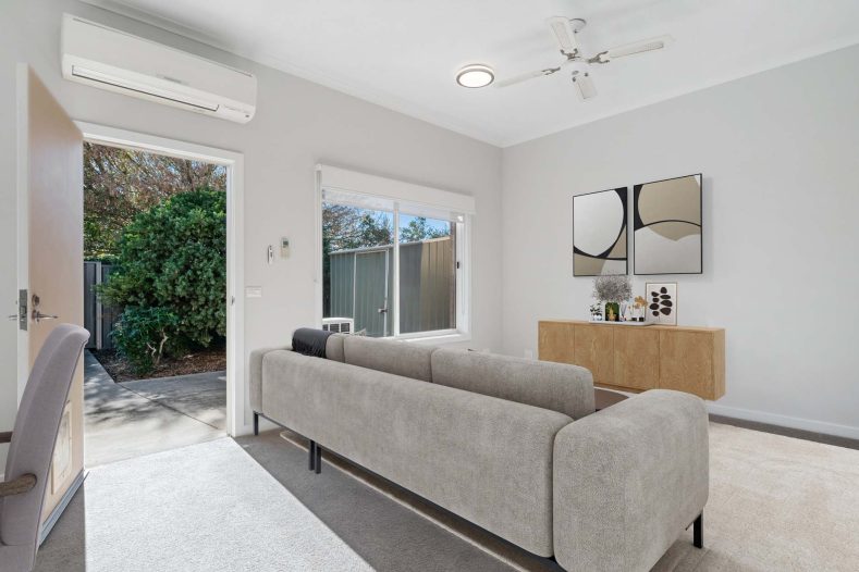 Near the couch, there is a door for garden access