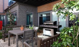 The BBQ area is captured with BBQ equipments available. There are also tables and chairs in the outdoor area.