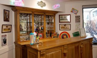 The bar area features a wall of glasses and wine.