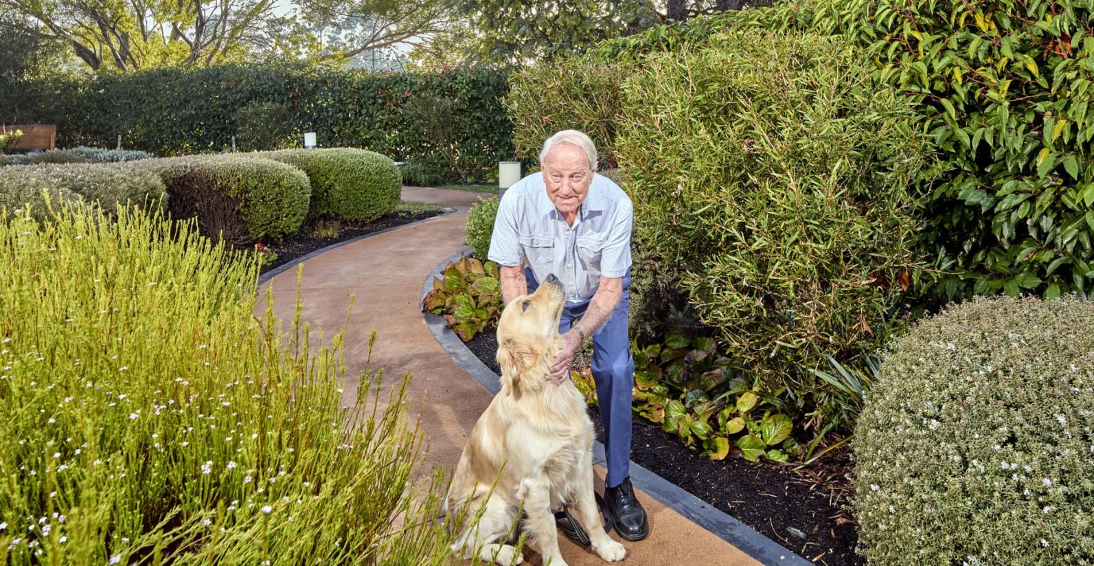 A resident and his dog are pictured in the garden area of Latrobe Community Strathdevon.
