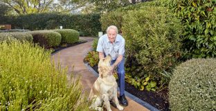 A resident and his dog are pictured in the garden area of Latrobe Community Strathdevon.