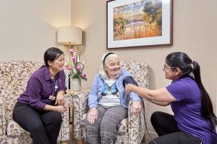 Resident and staff members are sitting together.