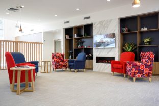 Lounge area captured, featuring furnitures in the area, including seating area, fireplace, built-in television and decorations.