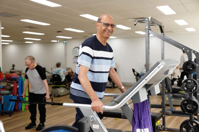 A Uniting AgeWell customer is using the gym equipment.