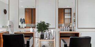 A salon with chairs and a variety of hair products is pictured.