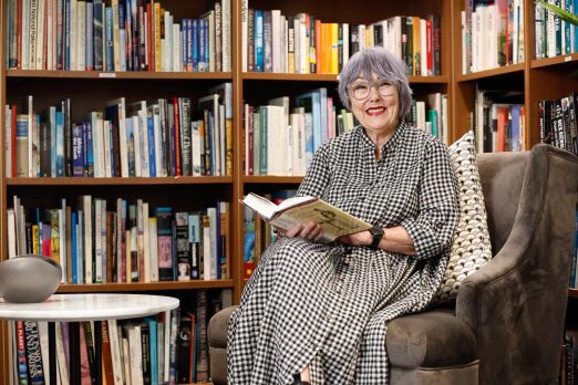 A resident is sitting in library at Manningtree Hawthorn.