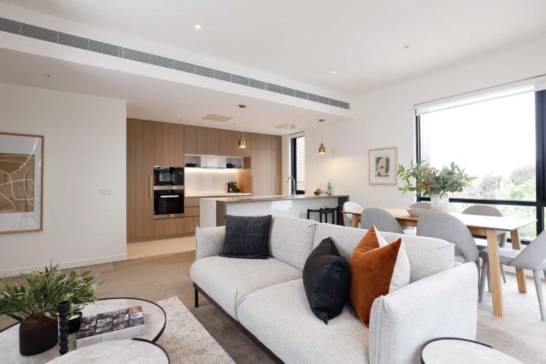 Overview of apartment living room, dining area and kitchen.