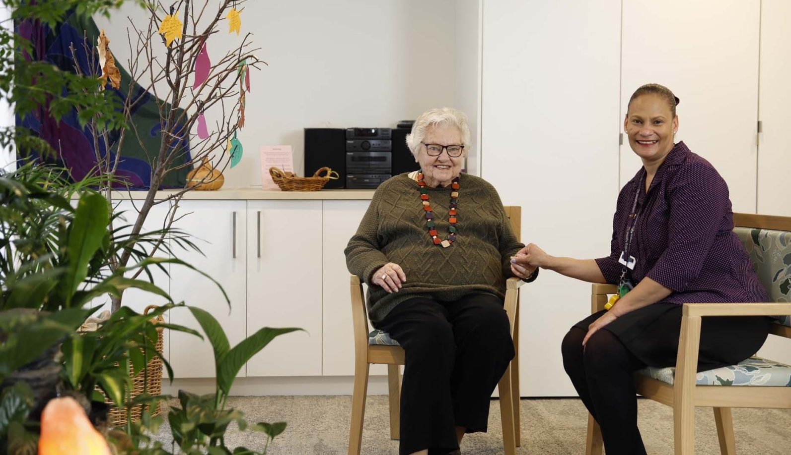 A chaplain and a resident are pictured, looking at the camera.