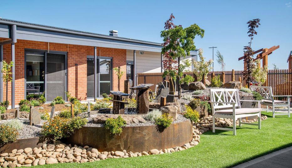 Newnham Community, Aldersgate Village outdoor seating and lawn is pictured.