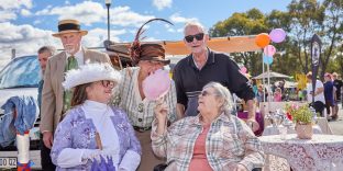 Four people smiling and enjoying fairy floss.