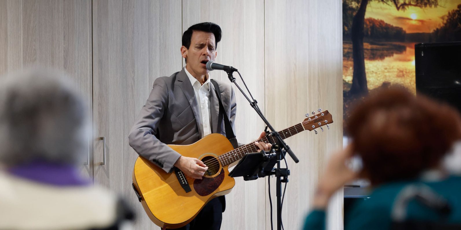 Entertainer singing and playing guitar at Preston Community.