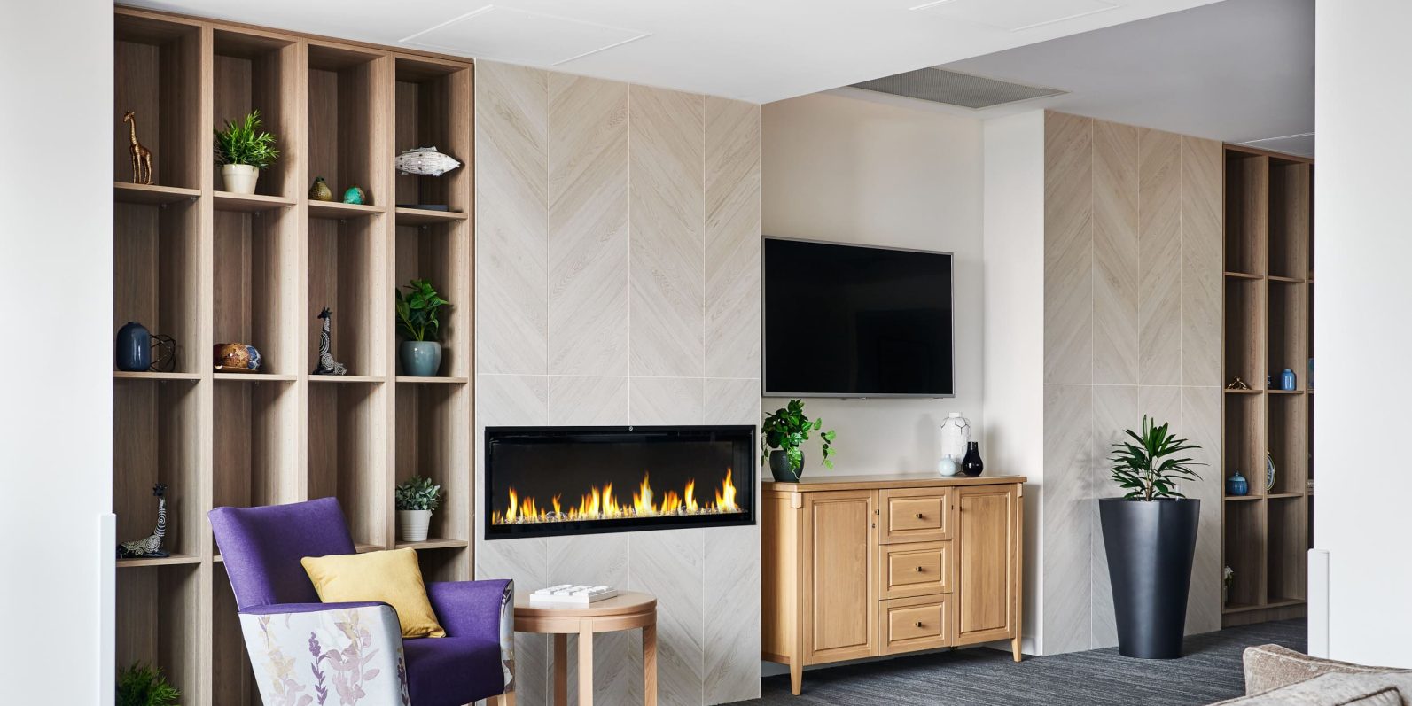 Preston Community living area with fireplace and TV is pictured.