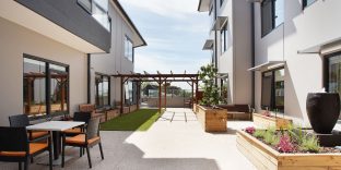 Preston Community light-filled outdoor courtyard with tables and chairs.