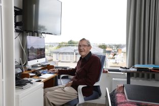 Resident in room at computer desk.