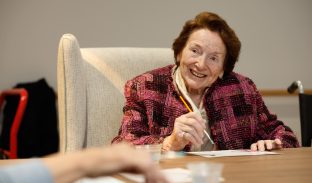 A resident smiles while painting