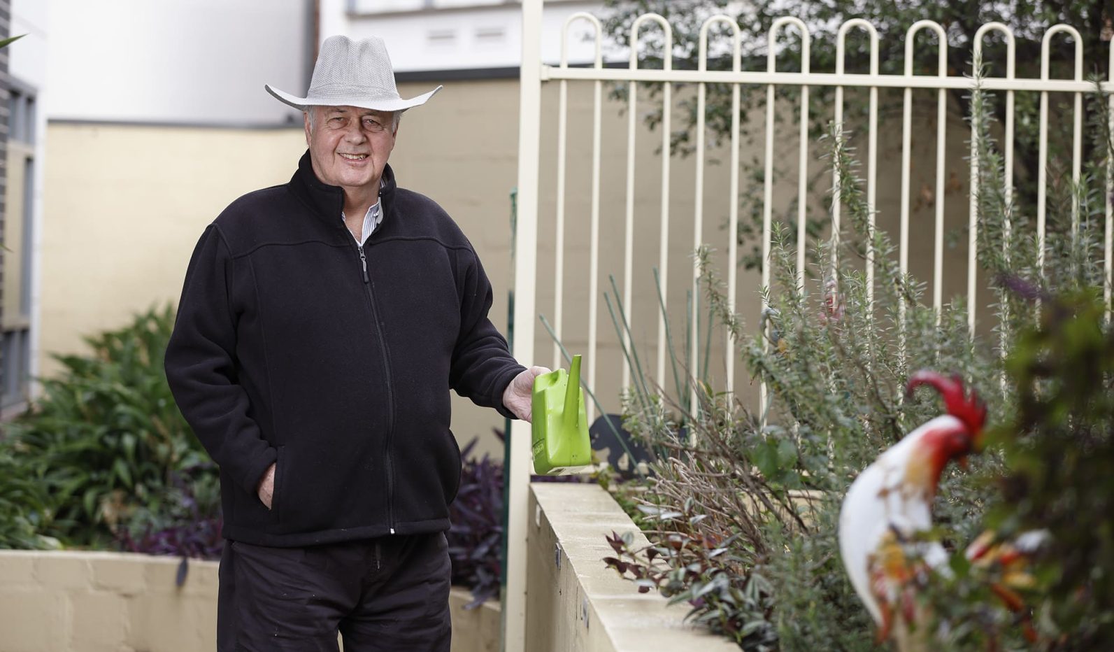 A resident smiles while standing in the garden area