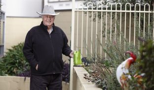 A resident smiles while standing in the garden area