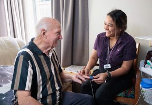 A resident and a staff member are interacting with each other.