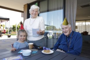 Two residents and a child are wearing party hats