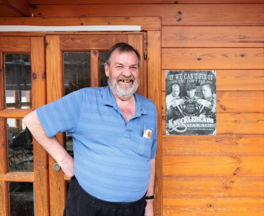 Resident standing in front of Men's Shed door