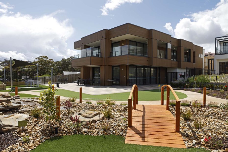 Exterior of building with chairs, tables and gardens pictured