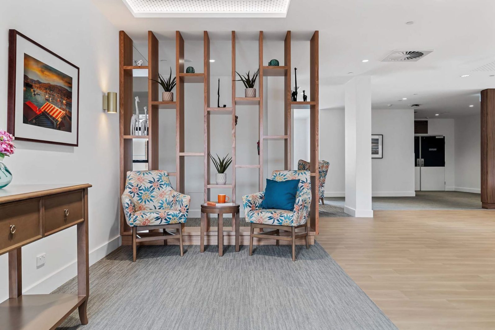 Light filled sitting room with two seats and a decorative partition wall