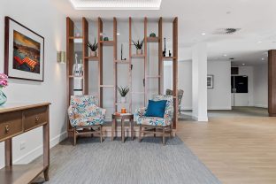 Light filled sitting room with two seats and a decorative partition wall