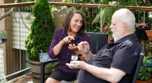 A staff member interacts with a resident in the garden area.