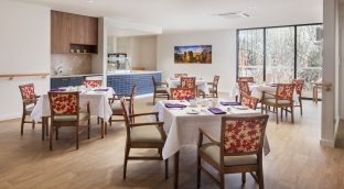 The dining area is captured with dining tables and a kitchen area.