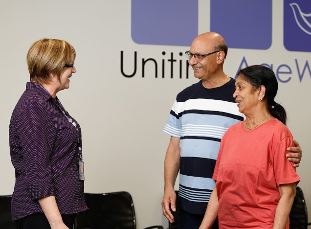 A staff member is greeting two customers in foyer