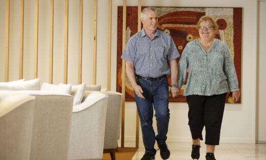 Two people walking in foyer holding hands.