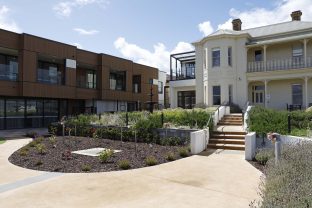 Exterior of Andrew Kerr Care Community with the home's modern facade visible alongside the historic Glenbank Mansion