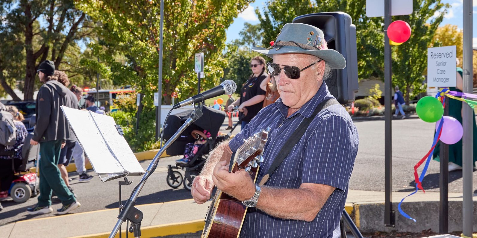 A person pictured playinig guitar under the sun.