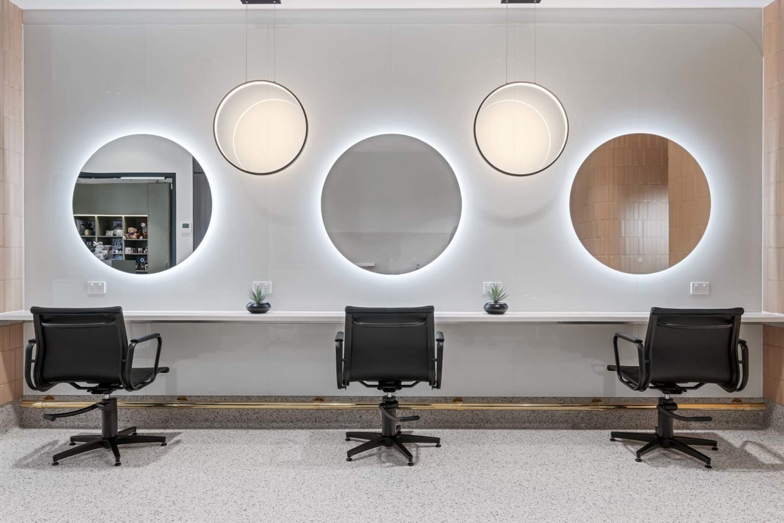 Three seats with mirrors in front of them are photographed.