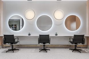 Three seats with mirrors in front of them are photographed.